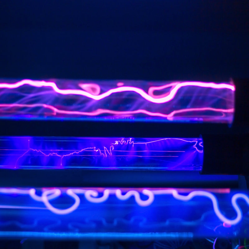 Close-up van UV-C lichtbuizen met paarse en blauwe gloed, gebruikt voor desinfectie tegen micro-organismen zoals huisstofmijt en bacteriën.